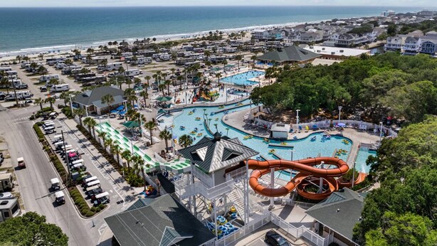 A resort with a large pool area, a water slide, and a view of the ocean. - *Fall into Savings-20% Off New Bookings thru 2026* (Myrtle Beach)