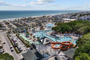 A resort with a large pool area, a water slide, and a view of the ocean. - *Fall into Savings-20% Off New Bookings thru 2026* (Myrtle Beach)