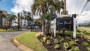 A sign for 'Dune Pointe' at 670 Santa Rosa Blvd, surrounded by a landscaped garden with palm trees and various plants.