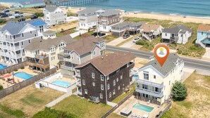 Zona residencial costera con varias casas, un muelle y una playa.