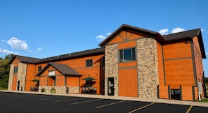 A hotel with a stone facade, wooden accents, and a parking lot. - King Hotel Room @ Spring Brook Resort (Wisconsin Dells)