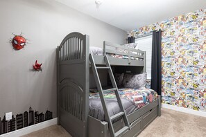 Een stapelbed met een ladder, een Spiderman muurdecoratie en een stadsgezicht muurdecoratie.