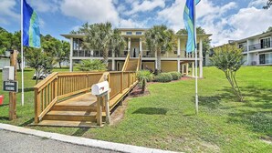 A two-story building with a wooden deck and a mailbox. - Ocean Springs Condo in Waterfront Resort! (Ocean Springs)