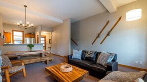 Un salon avec une table basse en bois, un canapé et un coin repas avec une banquette.