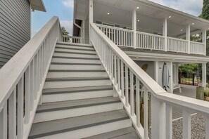 A staircase leading to a covered upper deck with railings and a view of the surrounding area.
