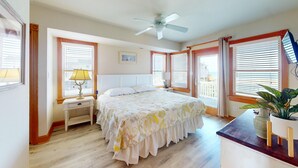 A bedroom with a bed, bedside tables, a ceiling fan, and windows with blinds. - Seaside | 6BR 4x4 OBX | Hot Tb | Sleeps 14 | 4 night stays available for fall (Carova)