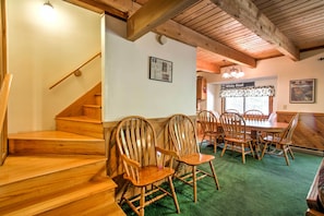 A wooden staircase leading to a dining area with a green carpet, wooden chairs, and a sign reading "Down White Heat". - Cozy Bartlett Townhome < 3 Mi to Attitash Mountain (Bartlett)