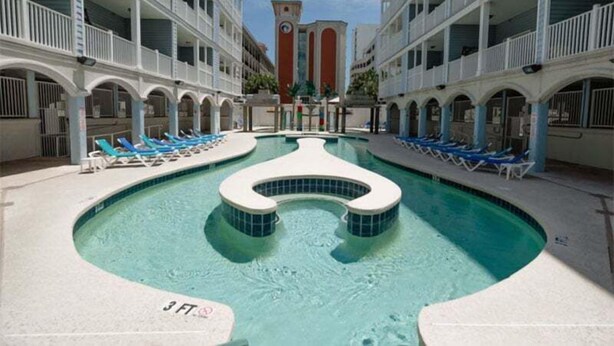 A pool area with lounge chairs and a central water feature.