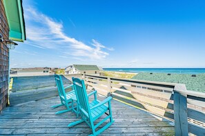 A wooden deck with two rocking chairs overlooking a beach. - The BU - S Nags Head MP 20, Ocean Views, 60 Ft to Beach, Pool Table, Hot Tub, Pets OK (South Nags Head)