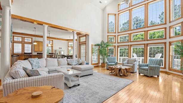 A spacious living room with a large sectional sofa, a coffee table, and a dining area with a wooden table and chairs. - Mi Casa Bella: Private pool, hot tub, dog friendly, golf discounts & gated c (Corolla)