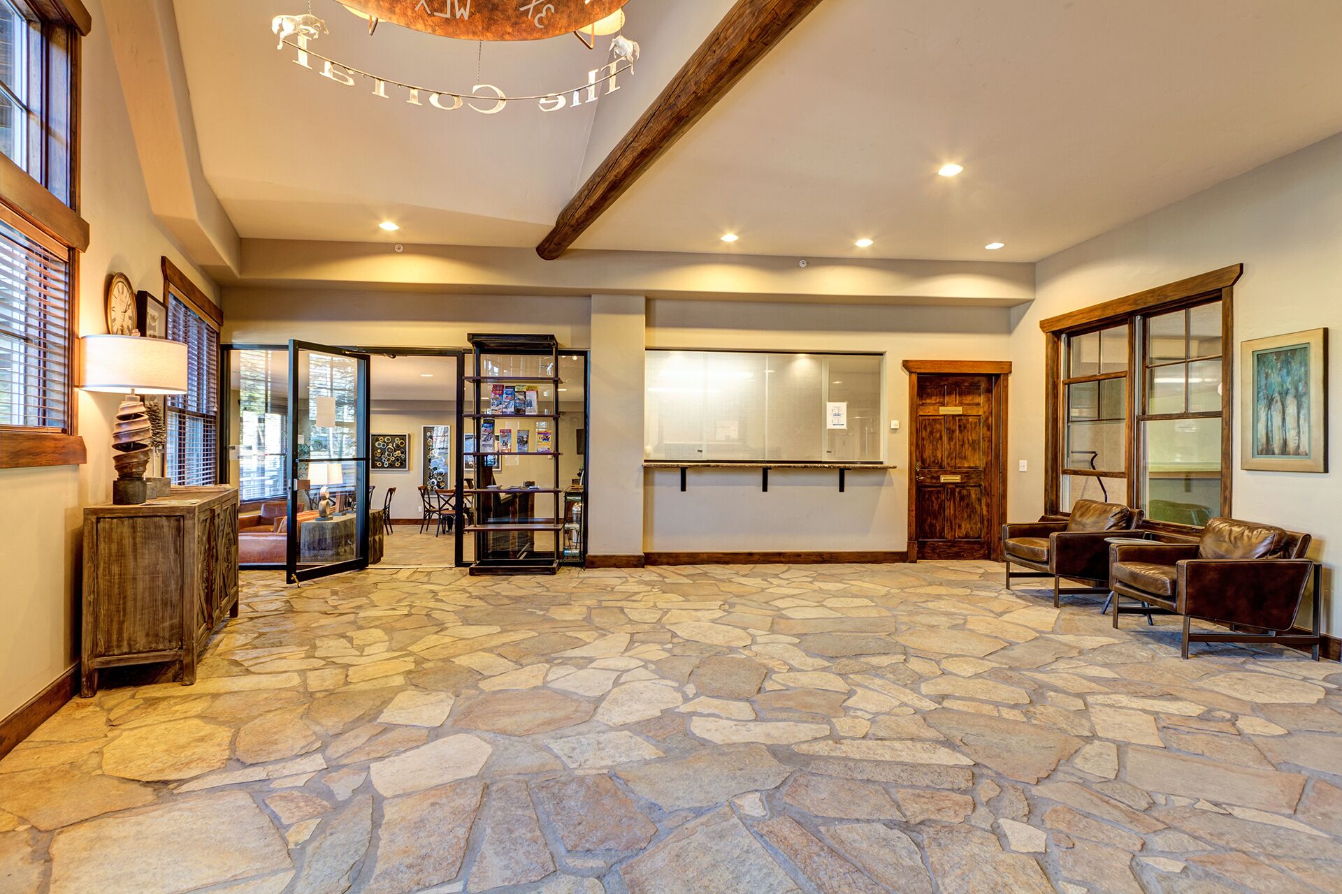 A spacious interior with a stone floor, a wooden bench, and a glass display case.