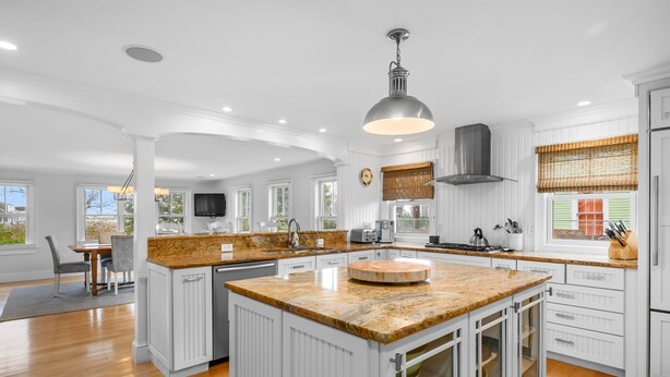 A spacious kitchen with white cabinetry, a large island, and a modern pendant light. - Walk to Beach and Town, Hot tub, Sleeps 8, Pet Friendly (Chatham)