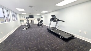 A fitness room with treadmills, an elliptical, and a stationary bike.