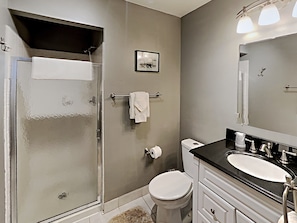 Une salle de bain équipée d’une douche, de toilettes, d’un lavabo et d’un porte-serviettes.