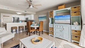 A modern kitchen with white cabinets, a central island, and a ceiling fan.