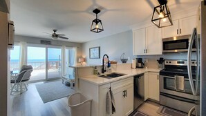 A kitchen with a large island, stainless steel appliances, and pendant lighting. - 910-B Turtle Cove: Beachfront Fun & Pool Access! (Surf City)