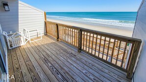 A wooden deck with a view of the beach. - 910-B Turtle Cove: Beachfront Fun & Pool Access! (Surf City)