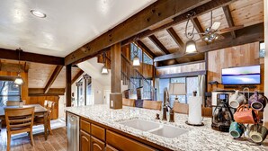 Una cocina amplia con encimeras de granito, armarios de madera y una isla grande.