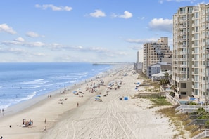 A beach with high-rise buildings, sandy shore, and a pier in the background. - Oceanfront condo - Short Drive to Dining/shops OOP 309 (Murrells Inlet)