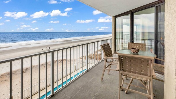 Een balkon met uitzicht op het strand en de oceaan.