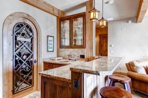 Enjoy cooking in this well-equipped kitchen with a central island, oven, and wine rack.