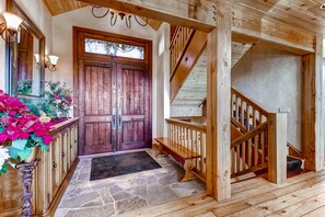 Stairs lead to a cozy space with a central door, flanked by wall-mounted lamps and a bench at the base.