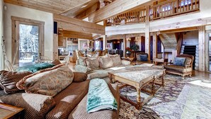 Ein großzügiger Wohnbereich mit hoher Decke, Holzbalken und einer gemütlichen Sitzecke mit Sofas und einem Couchtisch.