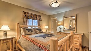 A cozy bedroom with a wooden bed frame, a large window with curtains, two bedside lamps, and a mirror on the wall. - 3 Mi to Ski Slopes! Hot Tub Haven in Breckenridge (Breckenridge)