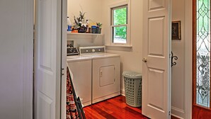 A laundry room with a washer and dryer, a window, and a door with a stained glass design. - Cozy Scottsville Cottage w/ River Views & Gazebo! (Scottsville)