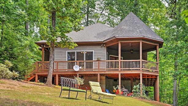 A two-story wooden cabin with a balcony, surrounded by trees. - Cozy Scottsville Cottage w/ River Views & Gazebo! (Scottsville)