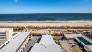 Une vue sur la plage, avec une piscine et un bâtiment doté d’un toit plat.