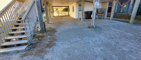 A covered outdoor area with a gravel path leading to a building entrance.