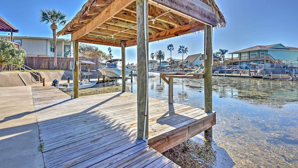 A wooden dock extending into a body of water, with a thatched-roof structure on it. - Private Dock, Views: Waterfront Rockport Home! (Rockport)