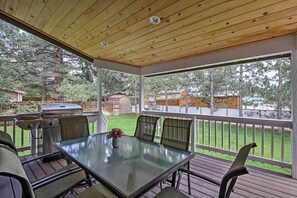 Enjoy al fresco dining on this patio with a grill, surrounded by lush greenery and a serene backyard view.