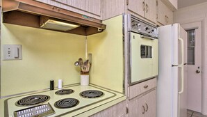 Eine Küche mit einem alten Herd, einem Backofen und einem Kühlschrank.