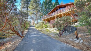 A wooden cabin with a covered porch, surrounded by trees and a clear sky. - Stunning Idyllwild Home w/ Private Hot Tub & Decks (Idyllwild)