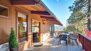 A wooden deck with outdoor furniture, a small potted plant, and a welcome sign. - Stunning Idyllwild Home w/ Private Hot Tub & Decks (Idyllwild)