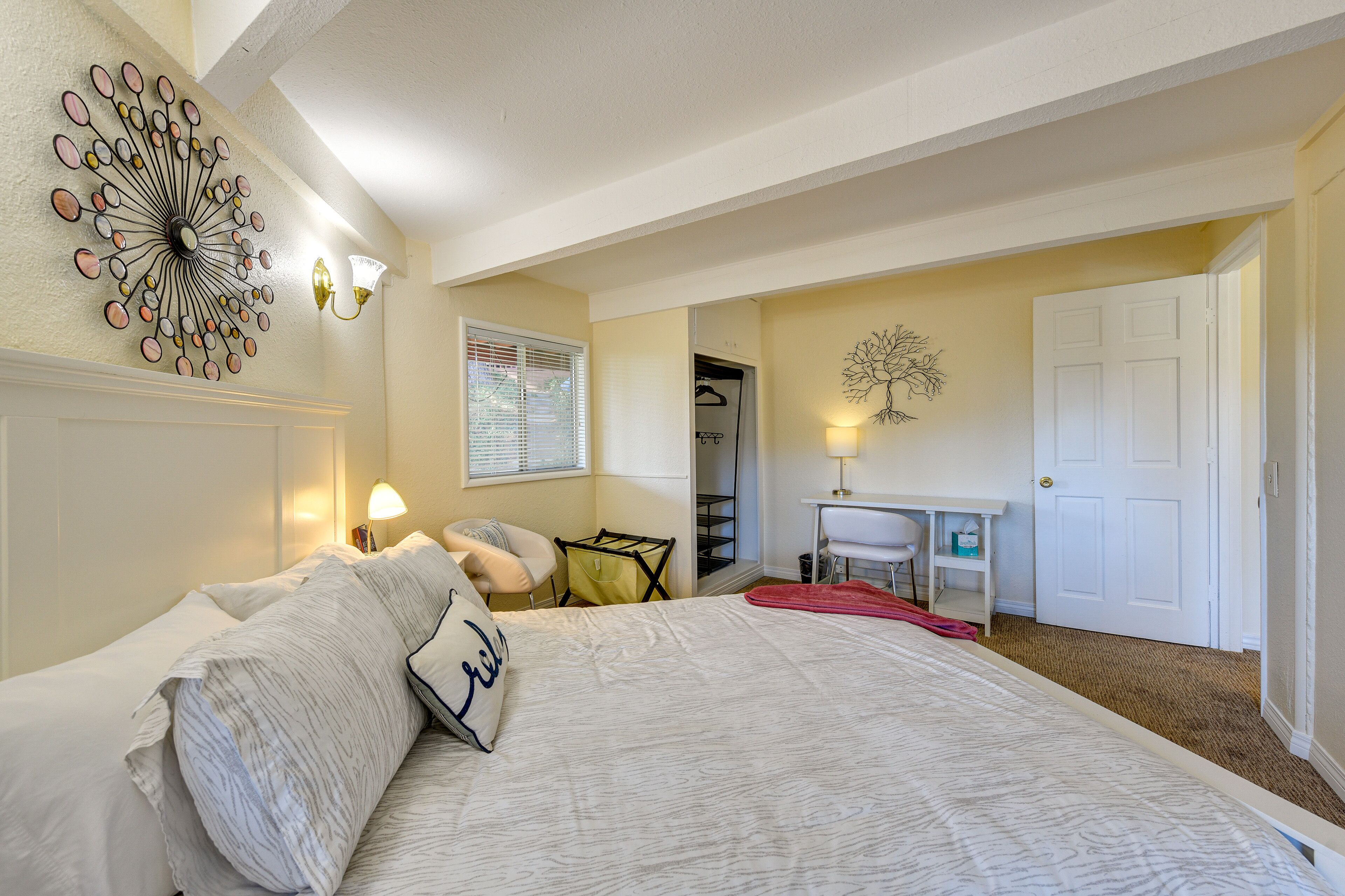 Un dormitorio con una cama grande, una obra de arte en la pared y un escritorio con una silla.