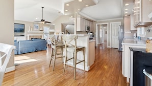 A spacious kitchen with wooden flooring, white cabinetry, and a central island. - Entire Home w/ pool, walk to beach (Virginia Beach)