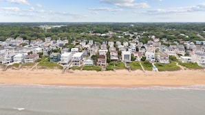 A coastal residential area with houses along the beach, featuring a sandy shoreline and a view of the ocean. - Entire Home w/ pool, walk to beach (Virginia Beach)