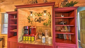 Una acogedora estación de café con una máquina de café, tazas y un letrero que dice 'Coffee'.