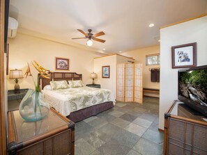 A hotel room with a bed, a ceiling fan, a TV, and a decorative plant. - Aloha Aku Hula Suite – Find Peace by the Shore (Kihei)