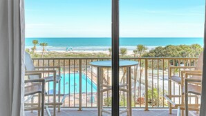 Een balkon met uitzicht op de oceaan, een zwembad en voorzieningen voor het strand.