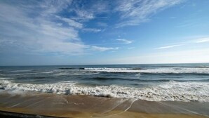 Een strand met golven en een heldere lucht.