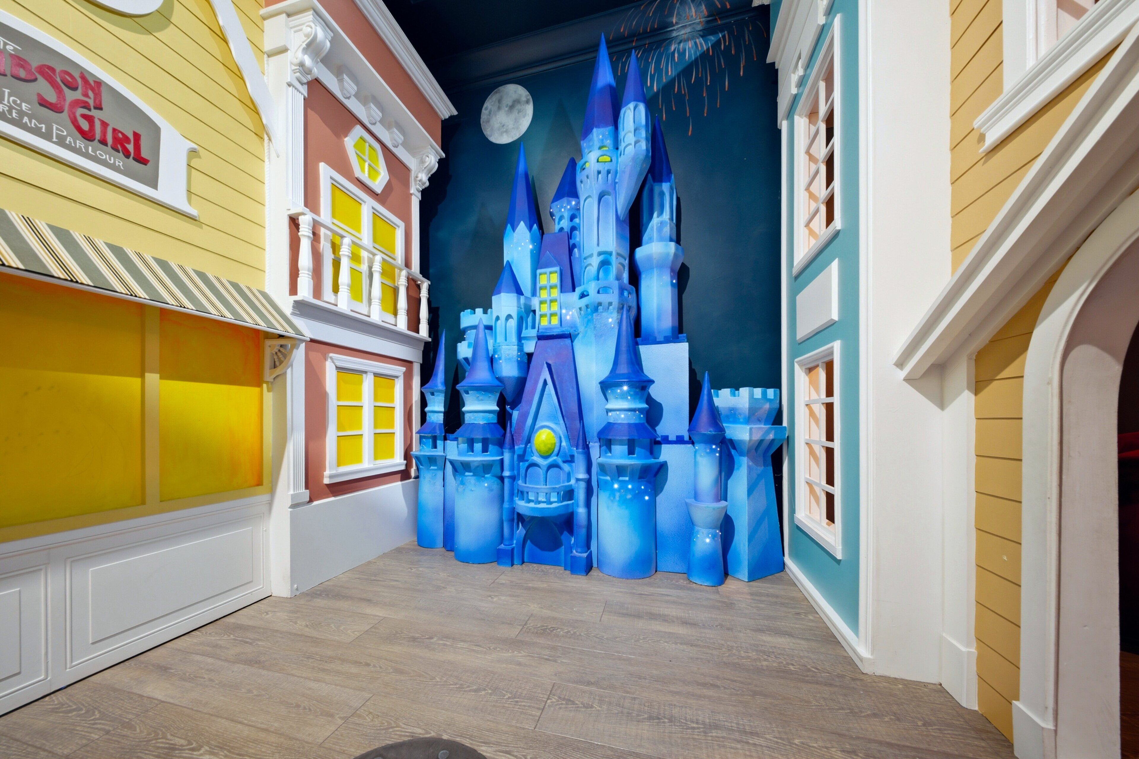 A children's play area with a castle backdrop and a sign for 'The Ice Cream Parlour'.