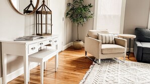 A room with a white desk, a chair, a round table, a potted plant, and a large mirror. - PORTLAND PENINSULA-SPACIOUS WALKABLE EAST END SPOT (Portland)