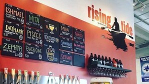A bar area with a variety of beer taps and a large glass of beer on a counter. - PORTLAND PENINSULA-SPACIOUS WALKABLE EAST END SPOT (Portland)
