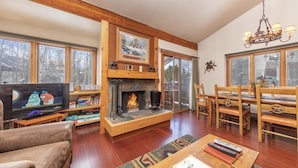 Una sala de estar acogedora con chimenea, muebles de madera y televisor.
