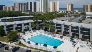 A hotel with a swimming pool, surrounded by tall buildings and a parking lot. - Peaceful Bay Side Retreat with Large Pool perfect for a family vacation (Ocean City)