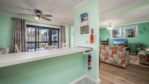 A living room with a sofa, a television, and a fireplace. - Peaceful Bay Side Retreat with Large Pool perfect for a family vacation (Ocean City)
